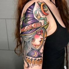 a woman's arm with a witch hat and moon tattoo on her left shoulder