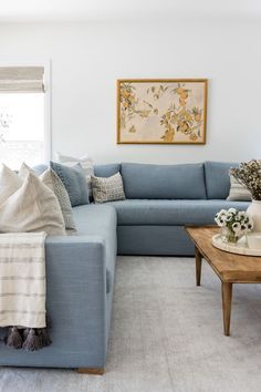 a living room filled with blue couches and pillows on top of it's covers