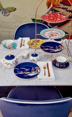 the table is set with plates, cups and saucers on it's trays