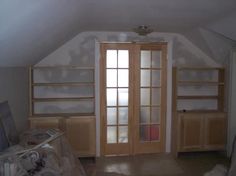 an empty room with wooden doors and shelves