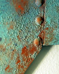 an old rusted piece of metal with holes in the middle and paint chippings on it