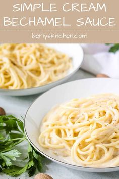 two white plates filled with spaghetti and parmesan cheese sauce on top of a table