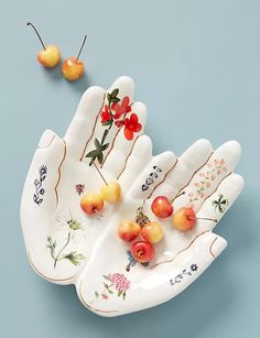 two hand shaped dishes with fruit on them