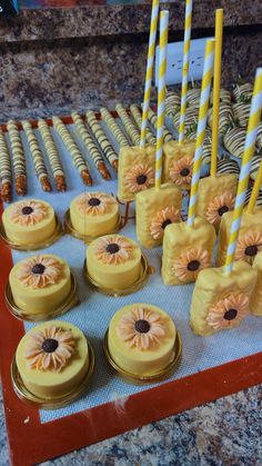 there are many cakes and candles on the trays that have been made to look like sunflowers