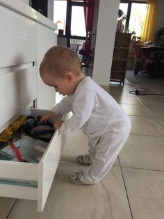 a small child is playing in the drawer