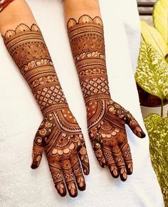 two hands with henna tattoos on them