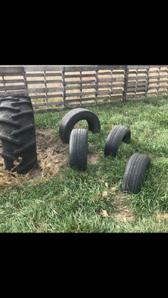 four tires and one tire laying in the grass