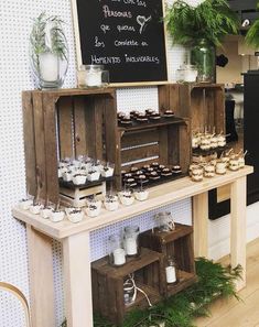 a wooden table topped with lots of cupcakes next to a chalkboard sign