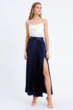 Discover timeless elegance with the Honor Pleated Maxi Skirt. Crafted from luxurious satin fabric, this maxi skirt is perfect for the modern sophisticate. The tall side slit adds a touch of drama, while the pleats create a timeless look that will never go out of style. Versatile with any blouse and for any occasion. Maxi skirt Pleated Side slit Length: 39 7/8" Waist: 13 3/4" Self: 97% Polyester, 3% Spandex Model is wearing a size small Style #: F2311S9316 Navy Pleated Skirt Outfit, Pleated Maxi Skirt Outfit, Blue Maxi Skirt Outfit, Movie Core, Maxi Skirt Outfit Summer, Navy Pleated Skirt, Skirt Outfits Aesthetic, Skirt Outfit Summer, Africa Trip