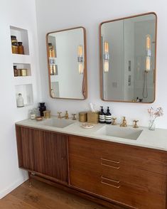 a bathroom with two sinks and mirrors on the wall