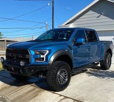 a blue truck parked in front of a house