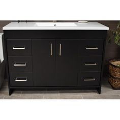 a bathroom vanity with drawers and a white counter top next to a trash can on the floor