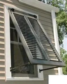 an open window on the side of a house with shutters and blinds pulled down