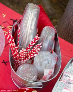 there are many plastic cups and straws in the bucket