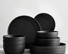 black plates and bowls stacked on top of each other