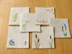 four napkins with flowers on them sitting on a table