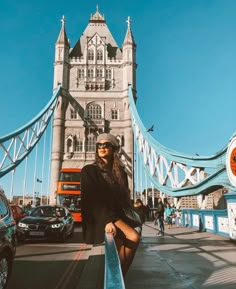 a woman standing in front of the tower bridge