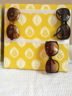 three pairs of sunglasses sitting on top of a yellow and white paper bag next to each other