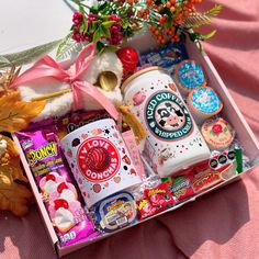 a box filled with lots of different types of candy and candies next to flowers