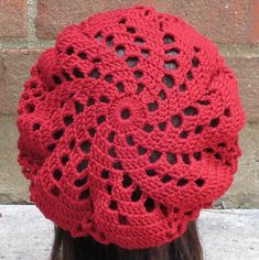 a woman wearing a red crochet hat on her head