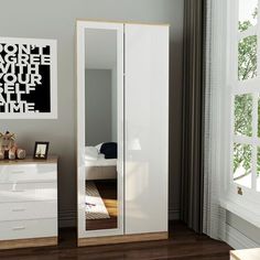 a bedroom with a large mirror on the wall next to a white dresser and bed