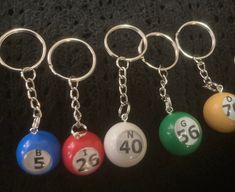 four pool balls with numbers on them are shown in this photo, and one has a keychain