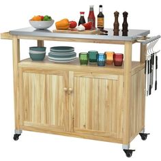 a kitchen island with plates and bowls on it's wheels, next to a bowl of fruit