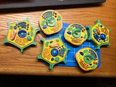 four toy cell phones sitting on top of a wooden table