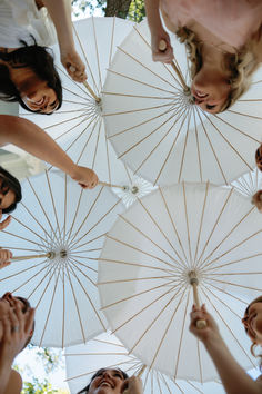 several people holding open umbrellas in a circle