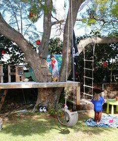 a woman in a blue dress standing next to a tree with an upside down swing