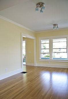 an empty room with hard wood floors and white walls