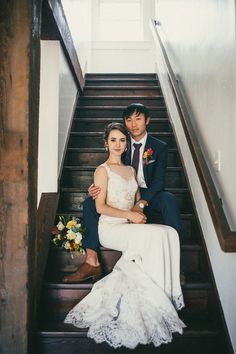 a bride and groom are sitting on the stairs