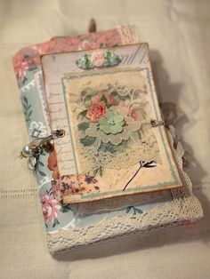 an altered photo frame with flowers and lace on the edge is sitting on a white tablecloth