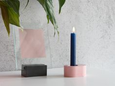 a blue candle sitting on top of a table next to a mirror