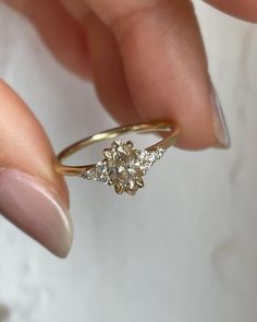 a woman's hand holding a diamond ring