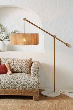 a living room scene with focus on the couch and floor lamp in the corner,