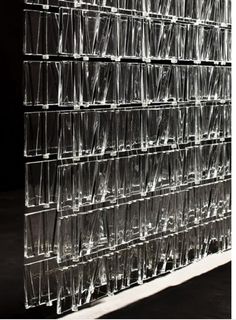 a large stack of clear plastic cups sitting on top of a table next to each other