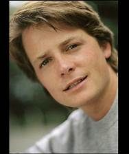 a close up of a person wearing a gray shirt and looking at the camera with a serious look on his face