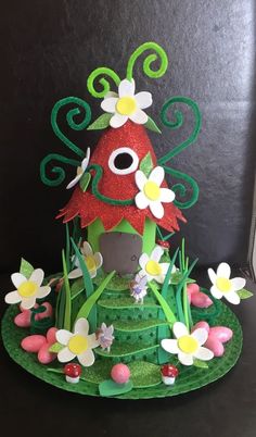 a green and red birdhouse with flowers on it