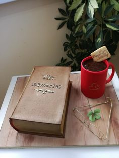 a cup of hot chocolate and a book on a tray with a corkscrew