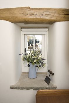 a vase filled with flowers sitting on top of a window sill next to a hammer