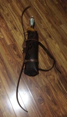 a brown leather bag on the floor with an arrow in it