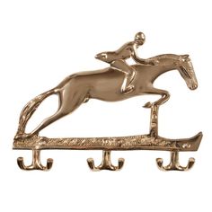 a gold horse and jockey coat rack with hooks