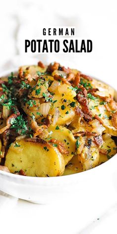 a white bowl filled with potatoes covered in bacon and parsley next to a fork