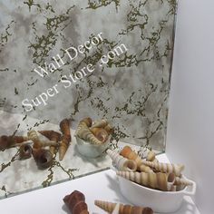 there are many different types of shells on the counter next to a glass sign that says wall decor super store com