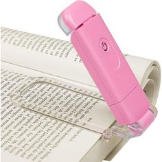 a pink electric toothbrush sitting on top of an open book