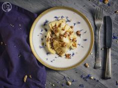 a plate with some food on it next to a fork and knife, sitting on a table