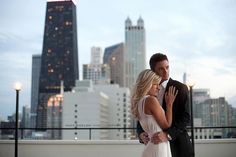 a man and woman standing next to each other in front of a cityscape