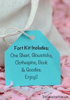 a blue tag that says fort kit includes one sheet, glowsticks, clothespins, book & goodies enjoy