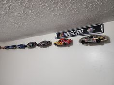 toy cars are lined up on the wall next to a sign that says misscar